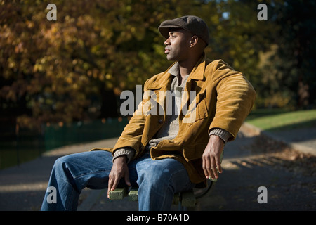 Homme d'origine ethnique africaine siège au banc de parc à Portland, Oregon. Banque D'Images