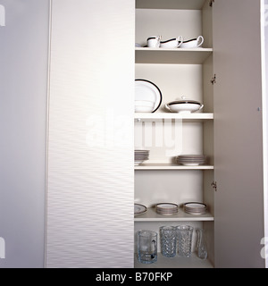Close-up of white placard de rangement avec portes ouvertes à la verrerie et de la vaisselle blanche sur des étagères Banque D'Images