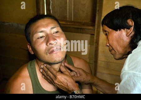 Le Suriname, Kwamalasamutu, accueil des peuples indiens. Chaman Indien Trio appelé Amasina examining patient. Banque D'Images