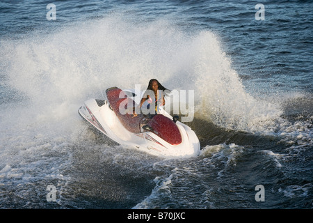 Le Suriname, plage de sable blanc, au sud de Paramaribo. Femme sur l'eau en scooter. Banque D'Images