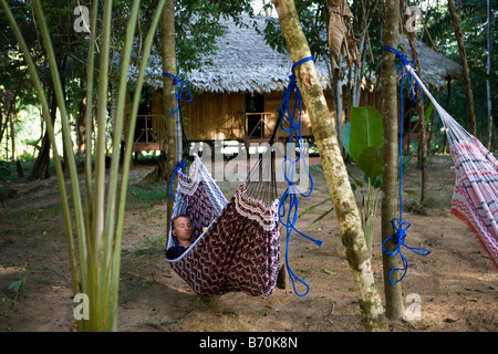 Le Suriname, Kwamalasamutu. Tourist in hammock at tourist lodge appelé Iwana Samu. Banque D'Images