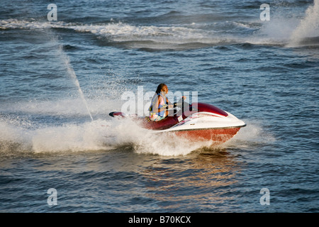 Le Suriname, plage de sable blanc, au sud de Paramaribo. Femme sur l'eau en scooter. Banque D'Images