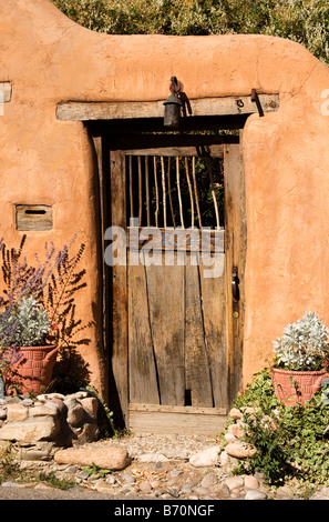 Une porte en bois dans un mur d'adobe à Santa Fe. Banque D'Images