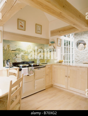 Tuiles paysage pictural crème crème ci-dessus en Aga pays cuisine avec parquet et placards en bois clair Banque D'Images