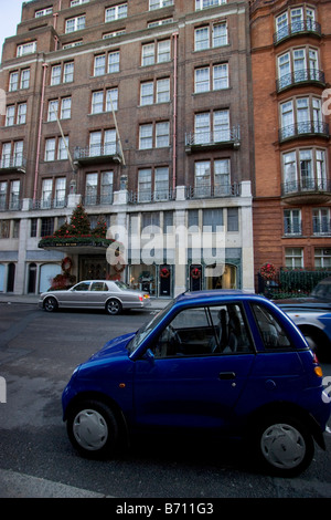 G Wiz voiture électrique centre de Londres avec Bentley en arrière-plan Banque D'Images