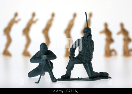 Toy Soldiers soldat communication radio mitrailleur et indifférent à être entouré par des soldats ennemis Banque D'Images