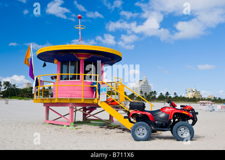 Miami South Beach , maître-nageur sauveteur ou rose art deco , bleu et jaune, avec des quad sur sable avec ciel bleu et soleil & nuages Banque D'Images