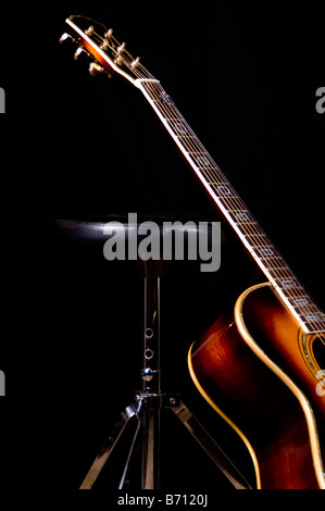 Guitare acoustique appuyé contre batteur tabouret de Banque D'Images