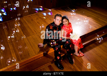 Jeune couple portant des vêtements traditionnels asiatiques assis à l'église autel Banque D'Images