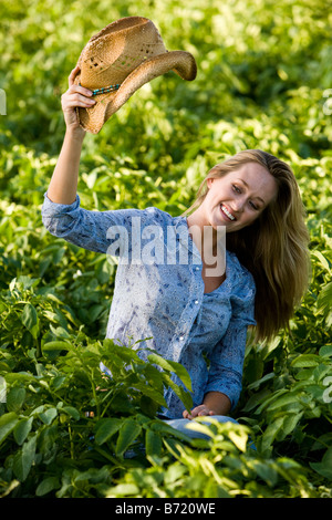 Jeune femme assise dans le domaine de la récolte de pommes de terre Banque D'Images