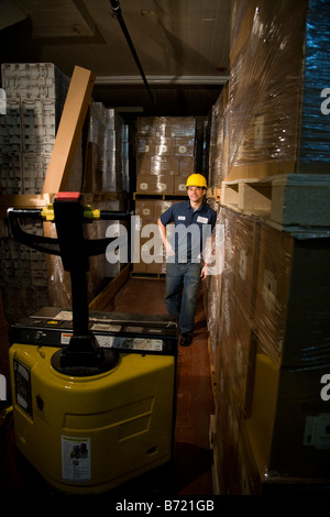 Male worker wearing hard hat dans l'allée de l'entrepôt de stockage Banque D'Images