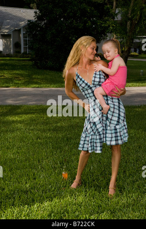 Mère tenant tout-petit avec le syndrome in backyard Banque D'Images