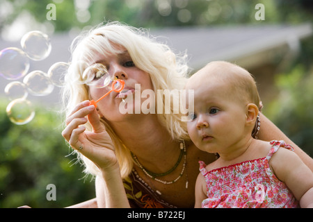 Close-up of mother faisant des bulles avec bébé à la Banque D'Images