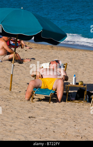 Palm Beach Shores Floride grandes adolescentes corpulent homme endormi soleil chaise longue plage sable mer bleue profonde de soleil Banque D'Images