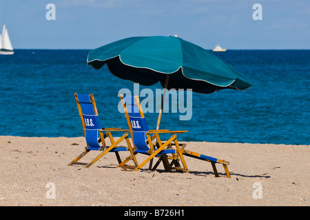 Scène de deux chaises longues et parasol vert foncé sur du sable sur plage avec Deep Blue Sea & Sky & sun & blanc bateaux par Banque D'Images