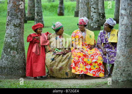 Le Suriname, Paramaribo. Femmes créoles dans Kotomisi robe, le costume créole national, dans le jardin de palmiers. Banque D'Images