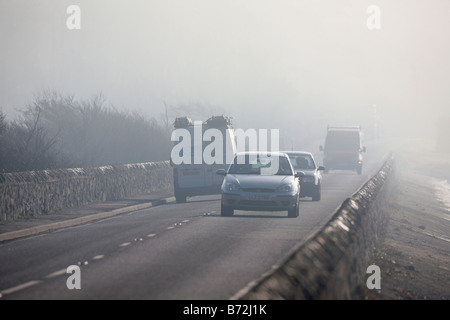 Les voitures et les camionnettes roulant le long d'une route côtière de brouillard le matin dans le comté de Down en Irlande du Nord UK Banque D'Images