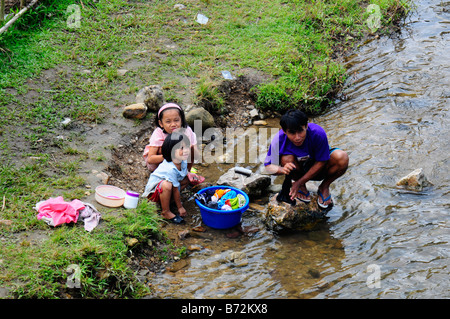 Famille de réfugiés lave leur linge dans la rivière près du camp de réfugiés de Maela,Tak,le nord de la Thaïlande Banque D'Images