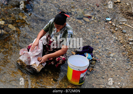 Femme de réfugiés est laver les vêtements dans la rivière près du camp de réfugiés de Maela,Tak,le nord de la Thaïlande Banque D'Images