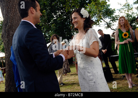 Groom lieux ring sur brides doigt quelques tour pour les invités ayant terminé une cérémonie civile à Garsington Oxfordshire Banque D'Images