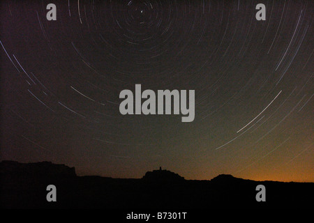 Trois heures d'exposition montrant starfield tournant autour de l'étoile polaire au-dessus de l'île de Skomer trig point sur l'horizon Banque D'Images