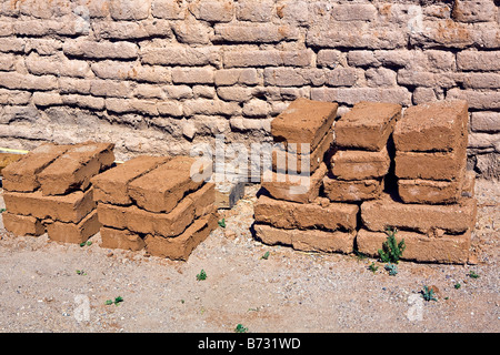 Image de briques adobe traditionnelles de séchage et empilés contre un mur de briques d'adobe dans le soleil Banque D'Images