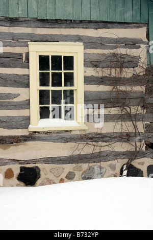 Un pays log cabin et châssis de fenêtre jaune dans le Wisconsin pendant l'hiver Banque D'Images