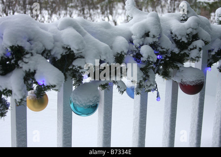 Un porche avec des décorations de Noël lumières et ornements couvertes de neige Banque D'Images