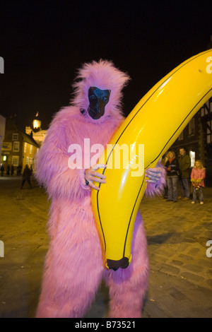 Un homme habillé comme un gorille rose transporte une grande banane dans un pub crawl noël à Lincoln UK Banque D'Images