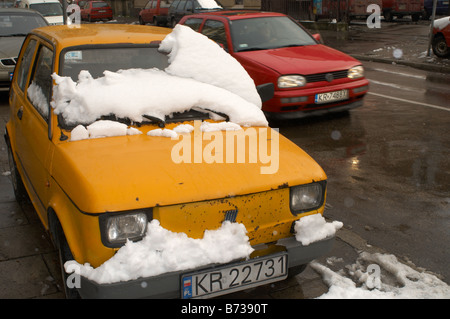 Une voiture Fiat couvert de neige fondante à Cracovie Pologne Banque D'Images