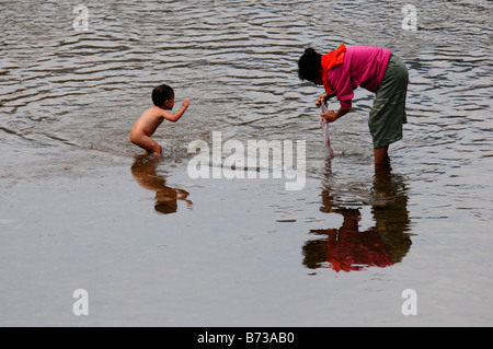 Petit enfant de réfugié est aimer marcher alors que la mère est la lessive dans la rivière près du camp de réfugiés de Maela,Tak,le nord de la Thaïlande Banque D'Images