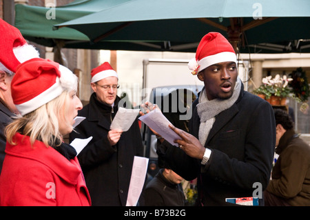 Carol singers à l'extérieur de l'église St Mary Le Bow, Cheapside, Londres, UK Banque D'Images