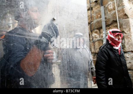 Les musulmans palestiniens devant la police antiémeute israélienne après avoir quitté prières à la mosquée Al Aqsa, dans la vieille ville de Jérusalem. Banque D'Images