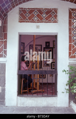 Assis à son artiste peinture de chevalet une photo dans son studio, Barrio del Artista ou artistes ville de Puebla, Mexique Banque D'Images