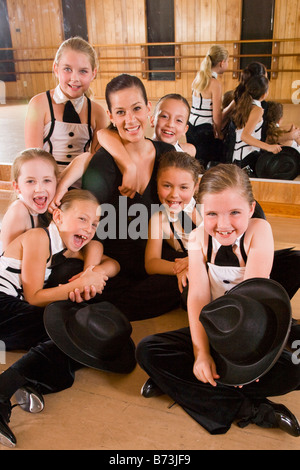 Les filles en costume posant avec un enseignant dans un studio de danse Banque D'Images