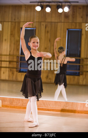 Girl practicing ballet dans un studio de danse avec miroir en arrière-plan Banque D'Images