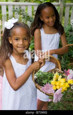 Afro-américaine cute girl holding panier de fleurs avec en arrière-plan Banque D'Images