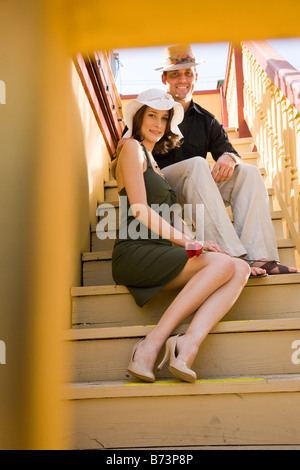 Portrait of romantic couple assis sur un escalier extérieur Banque D'Images