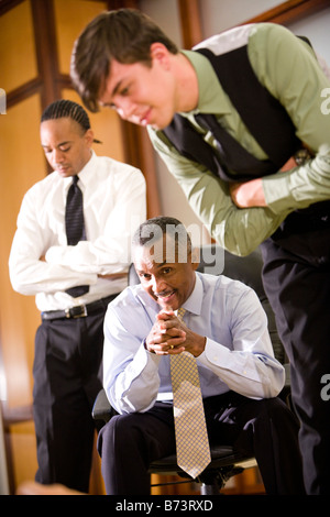 Close-up of young businessman, avec des hommes d'origine afro-américaine derrière Banque D'Images