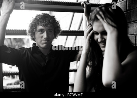 Jeune couple debout sous escalier Banque D'Images