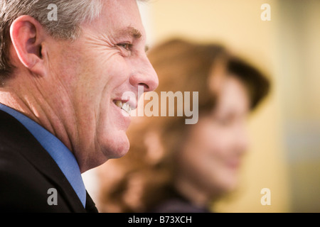 Profile of middle-aged man, woman in background Banque D'Images