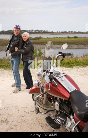 Portrait of happy senior couple standing near biker moto sur route de terre Banque D'Images