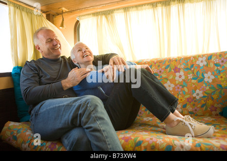 Romantic couple sur canapé en riant RV Banque D'Images
