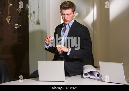 Young businessman looking down at laptop Banque D'Images