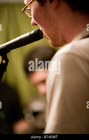 Close-up of young man singing into microphone Banque D'Images