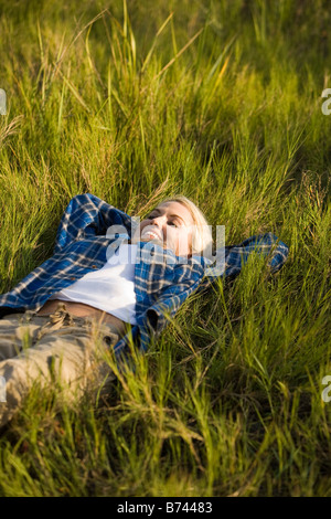 Young woman lying on grass, high angle view Banque D'Images