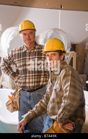 Les hommes portant des casques at construction site Banque D'Images