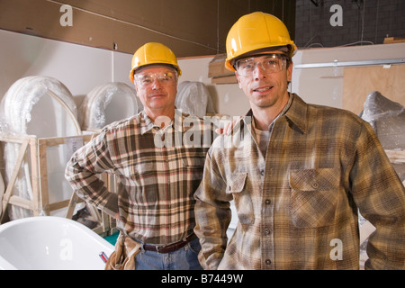 Les hommes portant des casques at construction site Banque D'Images