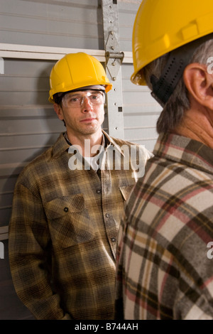 Male construction workers wearing hard hats Banque D'Images