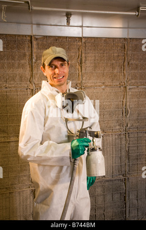 Portrait du peintre industriel avec des protections holding pulvérisateur de peinture Banque D'Images